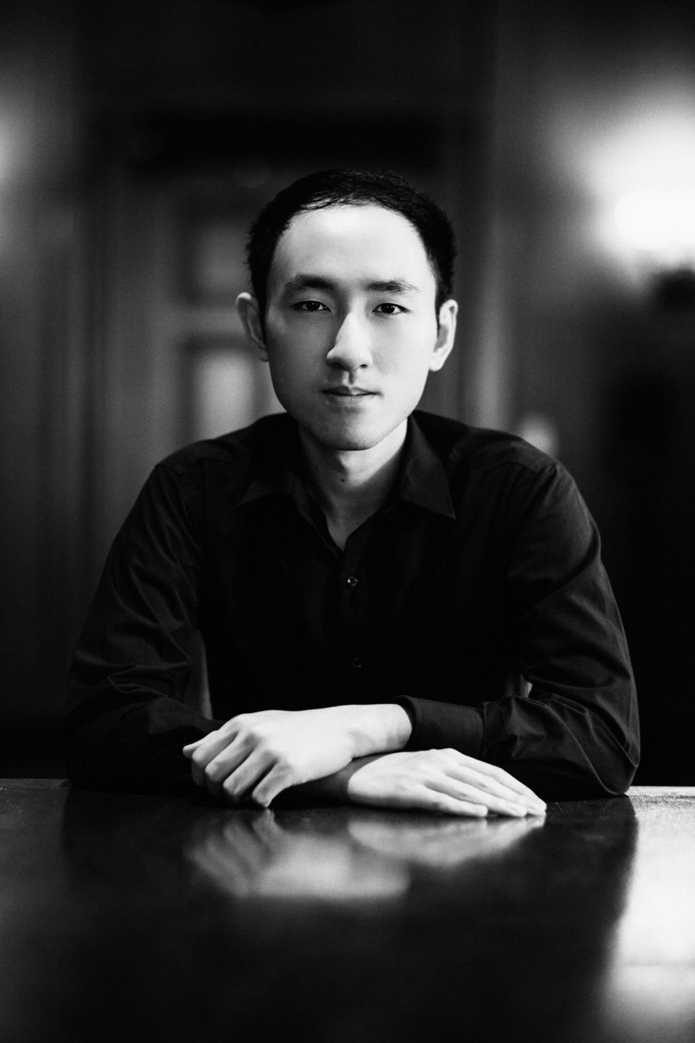 Haniel Anugerah black-and-white portrait seated at a table